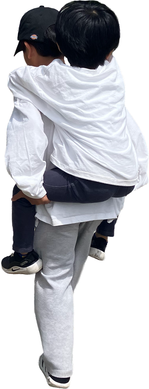 子どもをおんぶして歩く後ろ姿